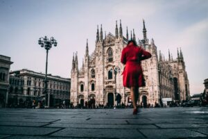 Una donna vestita di rosso davanti al duomo di Milano