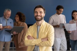 Un uomo sorridente al lavoro. Immagine di copertina dell'osservatorio 2024 di DoubleYou sul welfare aziendale